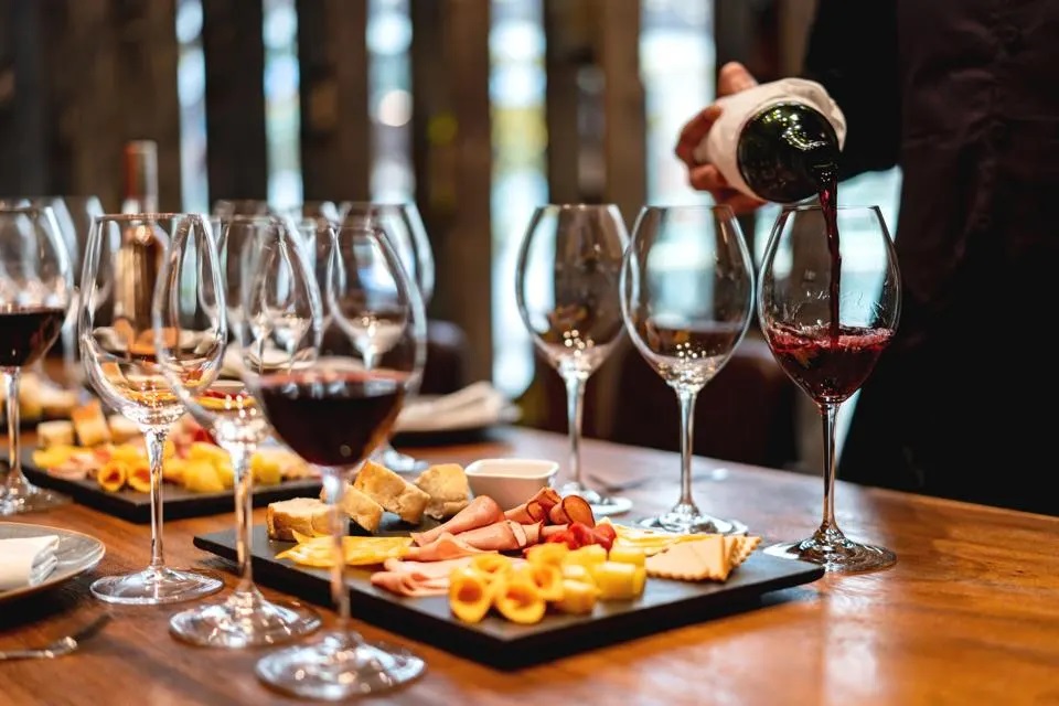 Professional wine tasting setup with multiple glasses and bottles arranged for blind tasting event